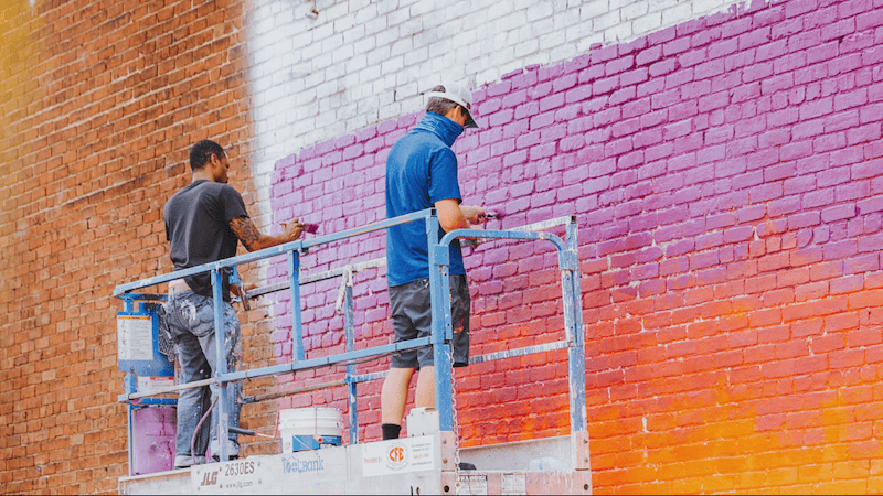 Hamilton Glass and other artist painting a mural in Richmond, Virginia, as part of the Mending Walls project. Used November 7, 2024